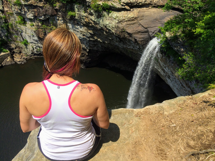 woman sits on cliff above DeSoto Falls Alabama